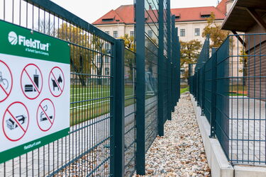 Blick auf Kiesweg zwischen zwei Zäunen